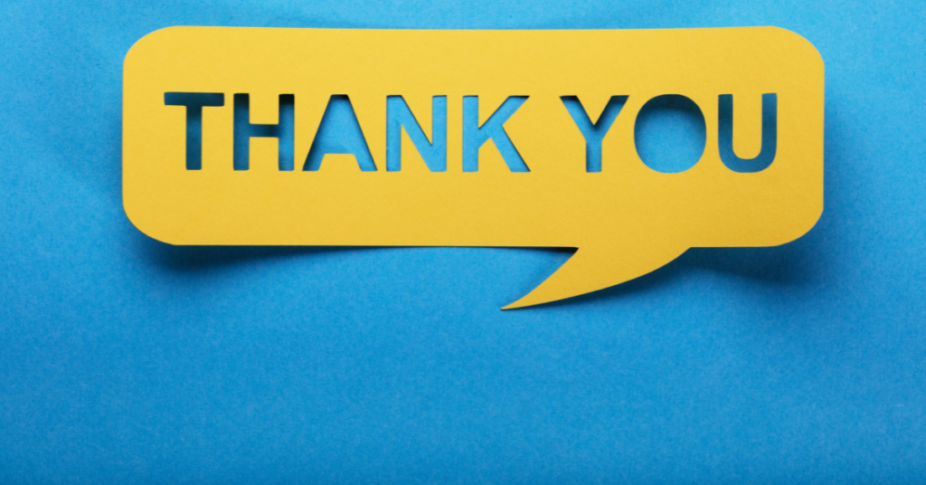A yellow paper cutout against a blue background reads “thank you”