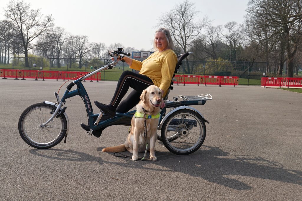 A woman in a mobility bike with her service dog.