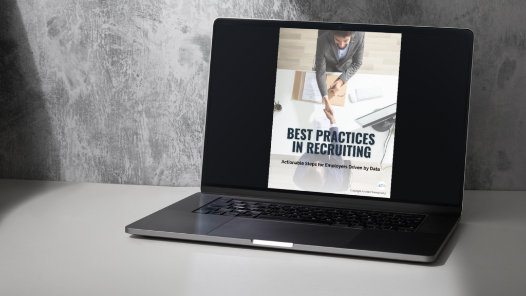 A gray laptop with the cover page of Another Source’s e-book, Best Practices in Recruiting, against a concrete backdrop